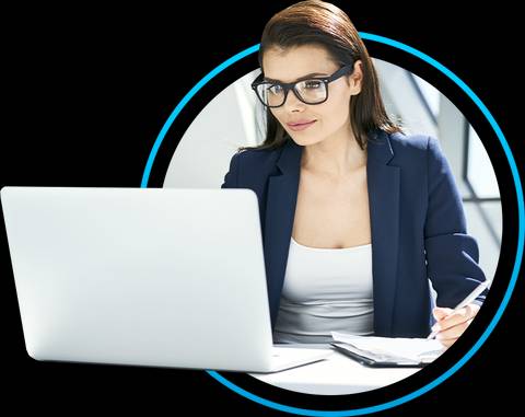 Una mujer con gafas está trabajando en una computadora portátil en un ambiente profesional.