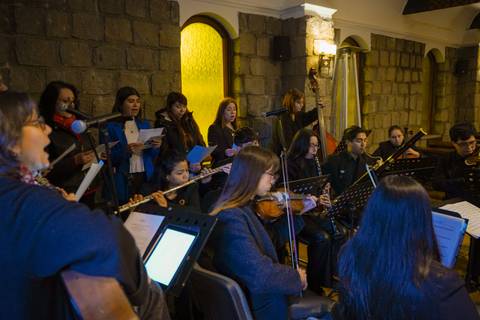 Un grupo de músicos chilenos interpretando canciones en un ambiente acogedor.