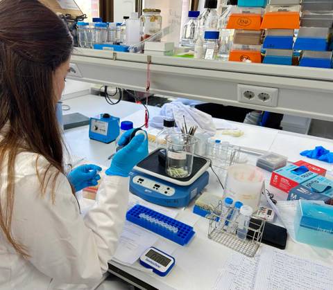 Una mujer en un laboratorio realiza experimentos con instrumentos científicos.