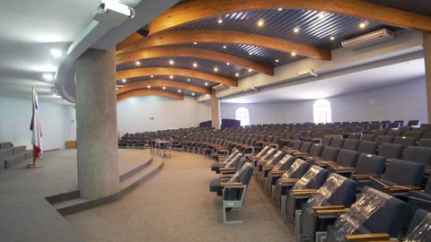 El interior de un auditorio con asientos dispuestos en filas y una iluminación suave.