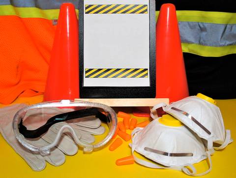 En la imagen se ven elementos de seguridad laboral como gafas, mascarillas, guantes y conos de señalización.