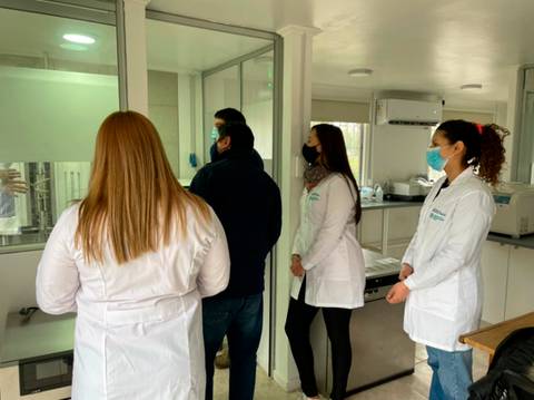 Un grupo de personas observa atentamente a un profesional en un laboratorio.