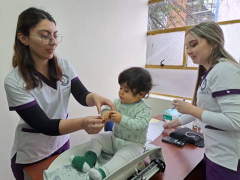 Una consulta médica donde dos profesionales de la salud atienden a un niño pequeño.
