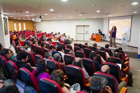 Una charla en un auditorio con muchas personas atentas en las butacas.