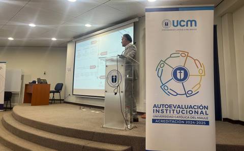 Un presentador expone sobre la autoevaluación institucional en la Universidad Católica del Maule.