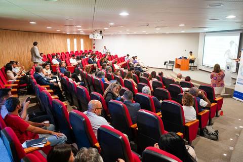 Una sala llena de gente participando en una charla o conferencia.