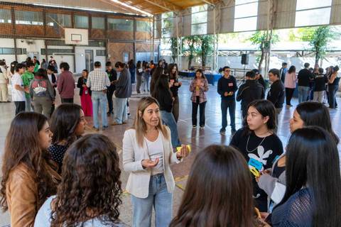 Un grupo de jóvenes interactúa en un evento en un gimnasio.