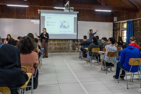 Una profesora enseña frente a un grupo de estudiantes en un aula.