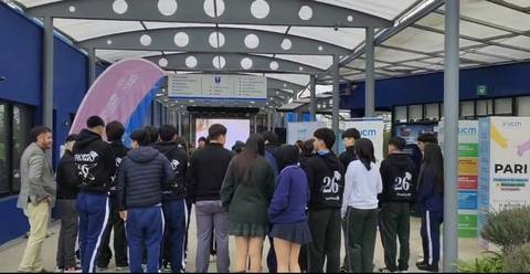 Un grupo de estudiantes observa atentamente una presentación en su colegio.