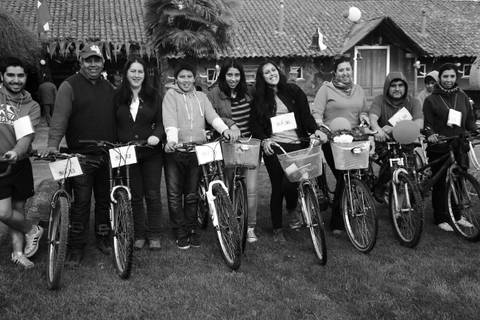 Un grupo de personas posa junto a bicicletas en un ambiente festivo.