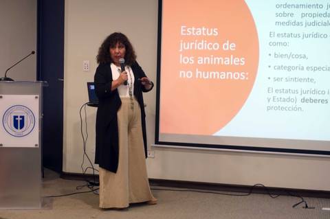Una mujer presenta sobre el estatus jurídico de los animales no humanos en una conferencia.