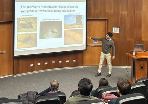 Un presentador habla sobre cómo los animales evitan condiciones extremas en una sala de conferencias.