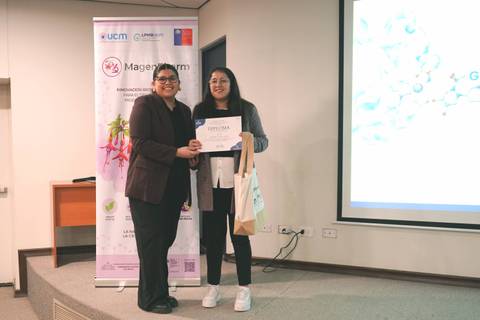 Una ceremonia de premiación donde dos mujeres posan con un certificado.