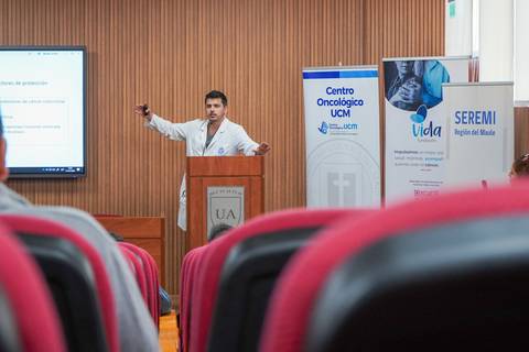 Un médico expone en una conferencia en un auditorio.