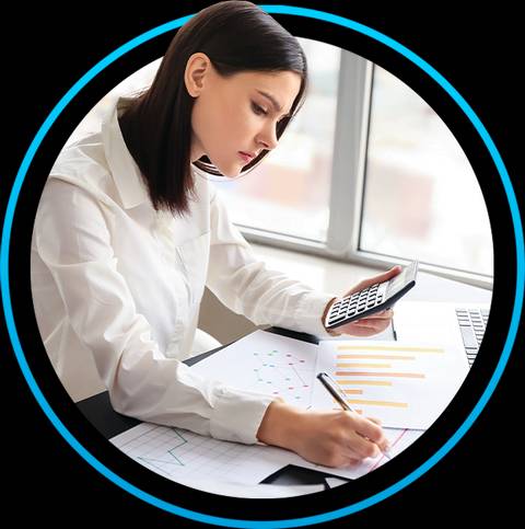 Una mujer está trabajando en su escritorio, usando una calculadora mientras escribe en un documento con gráficos y tablas.