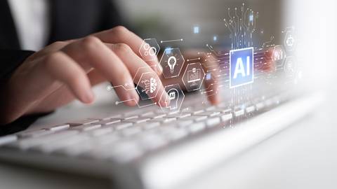 Una persona tecleando en un computador mientras interactúa con tecnología de inteligencia artificial.