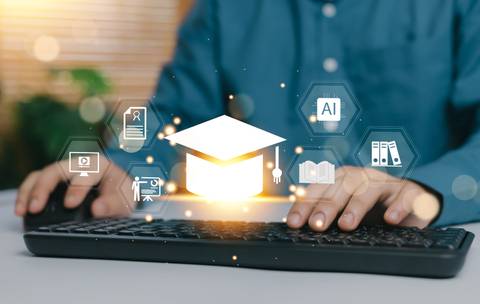 Una persona está usando un teclado mientras visualiza íconos relacionados con la educación y la tecnología.