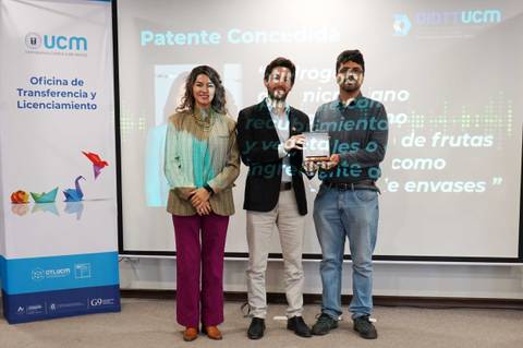 Un grupo de tres personas celebra la concesión de una patente en un evento académico.