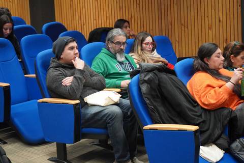 Un grupo de personas sentadas en una sala de conferencias.