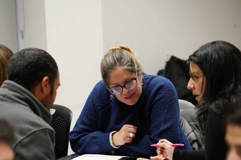 Un grupo de personas se encuentra conversando y trabajando en equipo en un ambiente colaborativo.