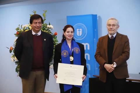 Una mujer con medalla y diploma en una ceremonia de premiación junto a dos hombres.