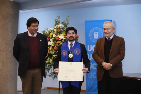 Un estudiante celebra su graduación con un diploma en mano junto a dos académicos.