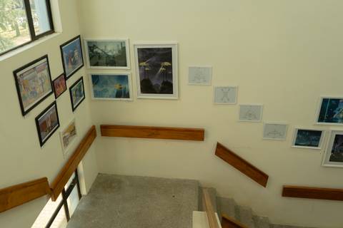 Una escalera con diversas obras de arte colgadas en las paredes.