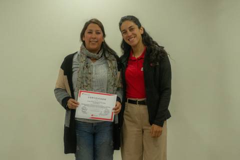 Dos personas celebran un logro con un certificado en mano.