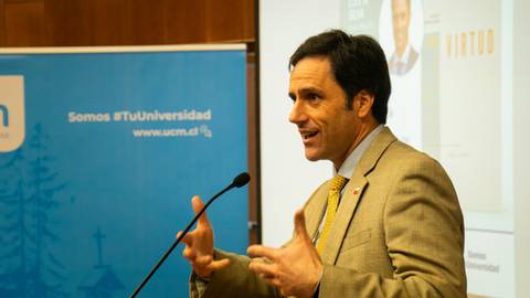 Un hombre habla apasionadamente en una conferencia universitaria.