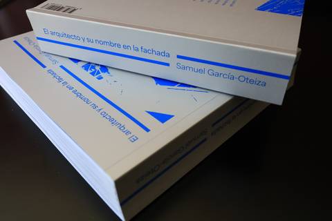 Un par de libros sobre arquitectura apilados sobre una mesa.