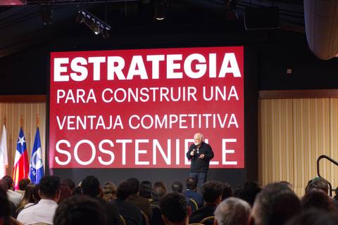 Un orador presenta una estrategia para lograr ventajas competitivas en un evento empresarial.