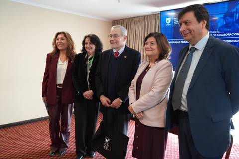 Un grupo de personas posando en un evento formal en una universidad chilena.
