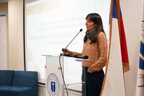 Una mujer presenta en un seminario sobre migrantes en la región del Maule.