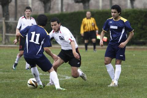 Un grupo de jugadores de fútbol compite en un partido en el campo.