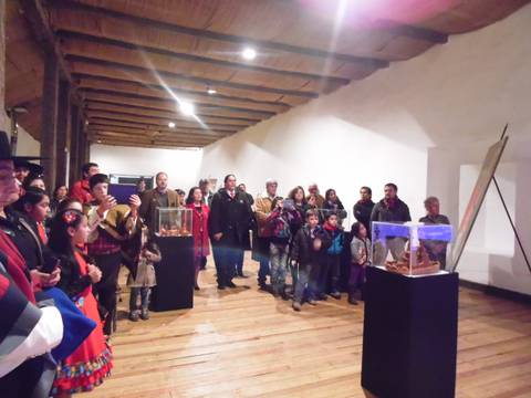 Un grupo de personas observa con interés una exposición en un museo.