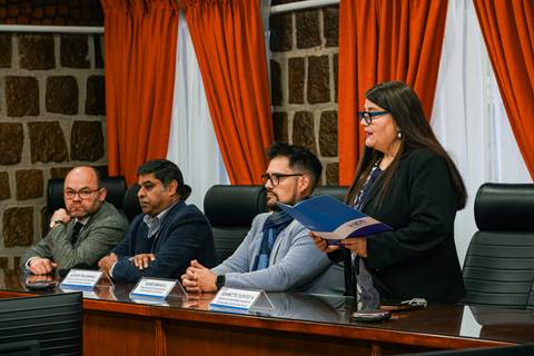 Un grupo de personas en una mesa durante una presentación formal.