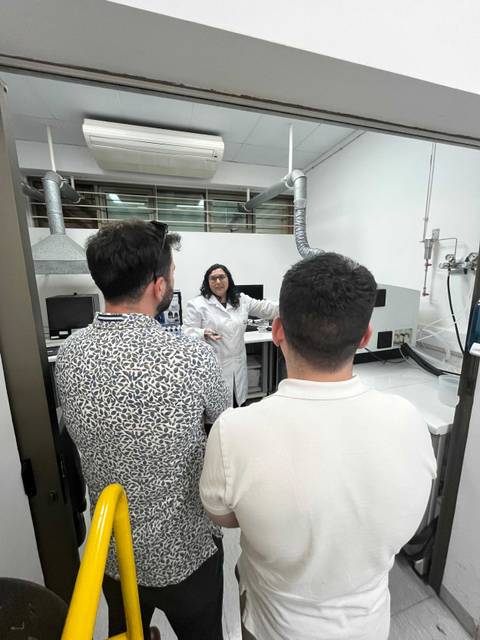 En un laboratorio, una persona explica algo a dos observadores.