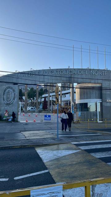 Entrada de la Universidad Católica del Norte con un ambiente tranquilo y soleado.