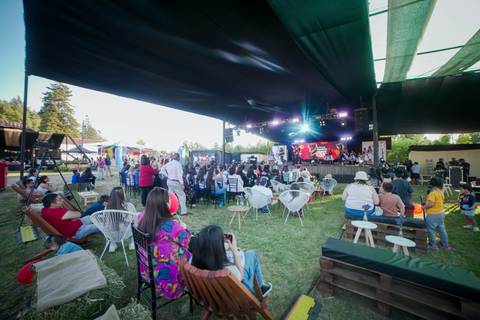 Un concierto al aire libre con un montón de gente disfrutando de la música.