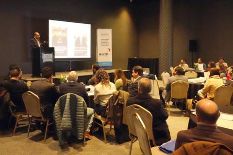 Un expositor presenta ante una audiencia en una conferencia en Santiago.