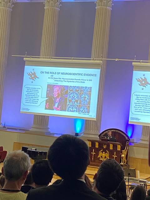 Una presentación sobre evidencia neurocientífica en un auditorio lleno de gente.