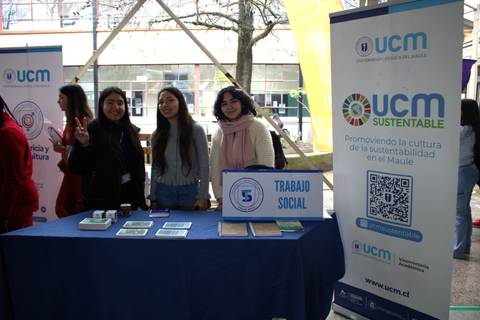 Un grupo de estudiantes sonríe en un stand de promoción de sostenibilidad en la UCM.