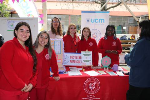 Un grupo de estudiantes en una feria mostrando su trabajo en obstetricia y puericultura.