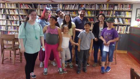 Grupo de niños y adultos sonriendo en una biblioteca.
