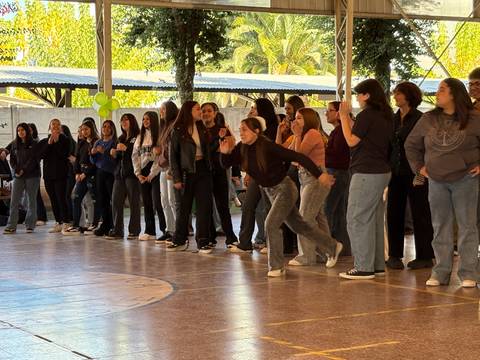 Un grupo de jóvenes se divierten participando en un juego en una actividad escolar.