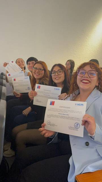 Un grupo de jóvenes sonrientes sosteniendo sus certificados en un evento de entrega de reconocimientos.
