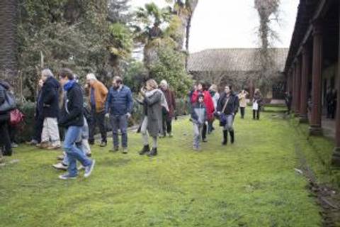 Un grupo de personas camina por un jardín con césped verde.