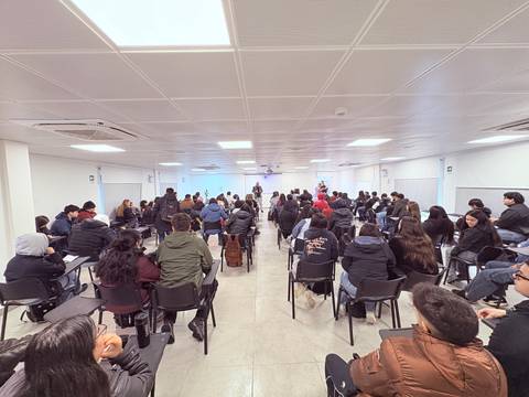Una gran cantidad de personas sentadas en una sala durante una charla o presentación.