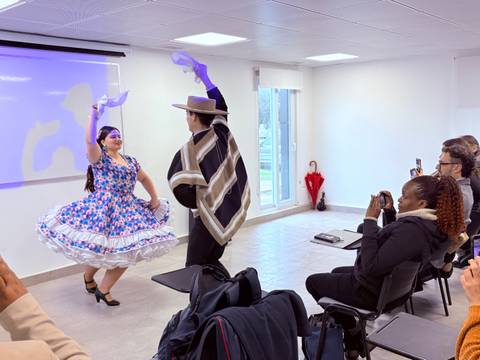 Una pareja bailando una danza típica chilena en un ambiente de clase.