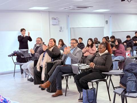 Un grupo de personas aplaudiendo en una sala de clases.